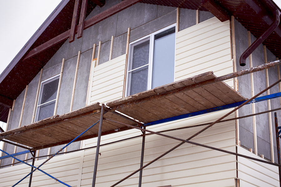 professional siding contractor working on wood siding 